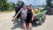 Happy Couple with Vibrant Green and Purple Boat
